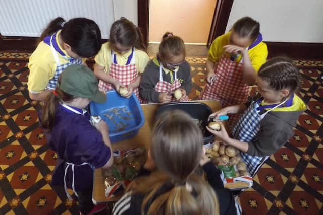 Girl Guides peeling potatoes.
