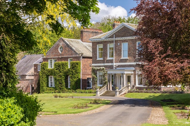 A closer look at the house frontage, with steps leading up to the pillared porch.