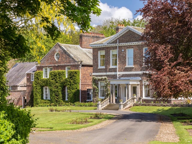 A closer look at the house frontage, with steps leading up to the pillared porch.