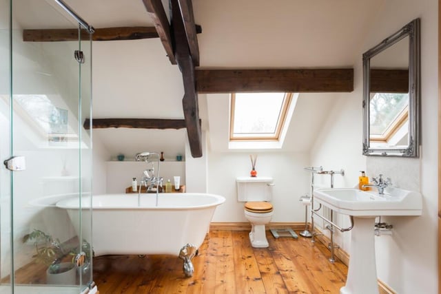 This bathroom's white suite includes a free standing bath tub.
