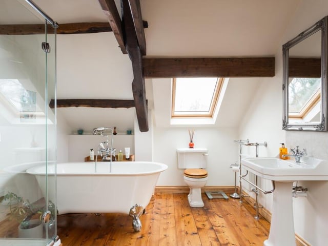 This bathroom's white suite includes a free standing bath tub.