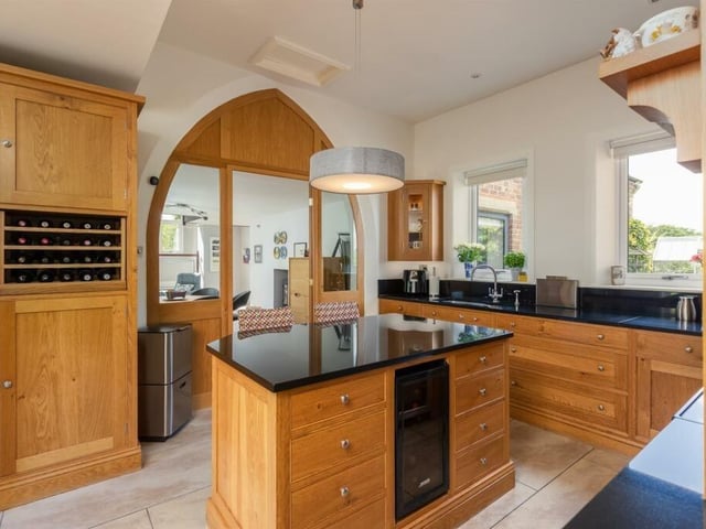 A handcrafted oak kitchen has granite worktops and a central island.
