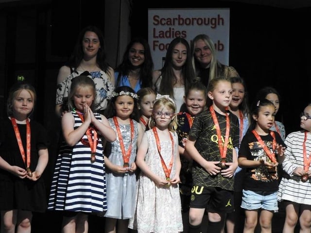 The SLFC Soccerettes collect their medals and awards.