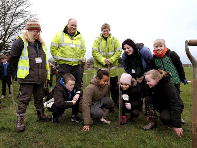 Pupils, staff and volunteers enjoying the planting experience.