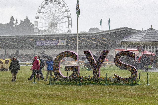 A heavy downpour sends visitors running for cover on the first day of the show