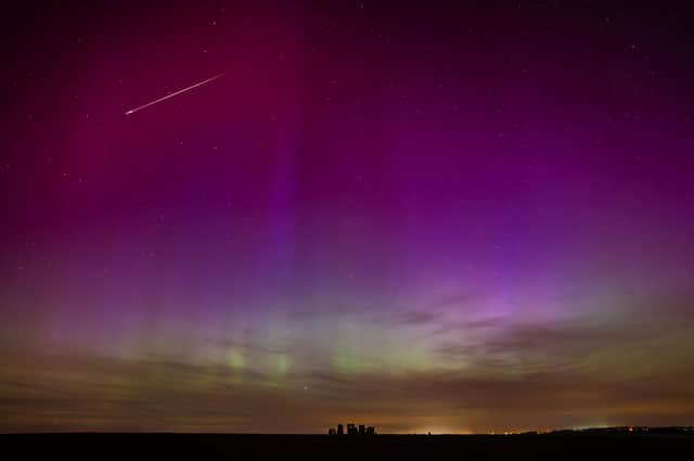 Incredible aurora display at Stonehenge captured in May 2024. It also features a bright fireball meteor (shooting star) top left. Photo: Astro Dog.