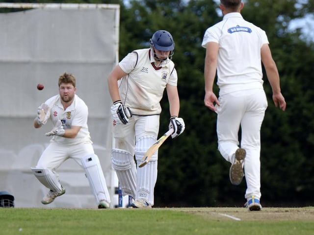 Seamer batter Archie Graham misses out while Flixton keeper Will Norman looks to pouch the ball