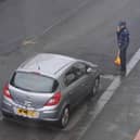 A traffic warden surveys the scene