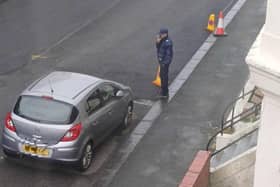 A traffic warden surveys the scene