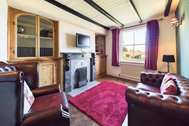 A ground floor snug with open fireplace and built-in cupboards.