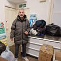 Mehmet Kaya with some of the items that have been collected, the storerooms behind him are also filled with coats donated by the people of Scarborough
