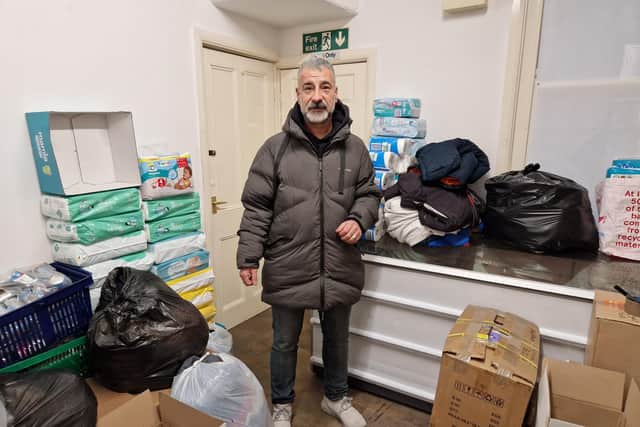 Mehmet Kaya with some of the items that have been collected, the storerooms behind him are also filled with coats donated by the people of Scarborough