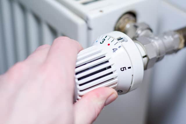 Adjusting a heating thermostat.