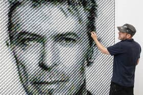 Artist Joe Black adds the finishing touches to a portrait of David Bowie made from over 8,500 guitar plectrums, commissioned by Sky Arts to celebrate Bowie topping a new definitive list of Britain's 50 most influential artists of the past 50 years