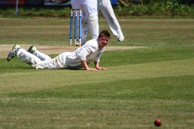 A Scalby CC bowler looks on as the ball flies past him.