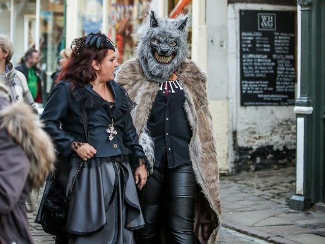 A woman and a werewolf parade down Church Street at the Whitby Goth Weekend (2017).