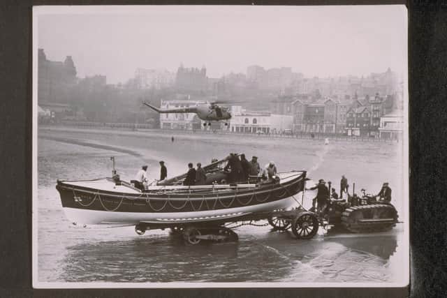 Scarborough station. ON 792 Liverpool Motor, Annie, Ronald and Isabella Forrest being launched by tractor, a helicopter hovering above. January 1958. (Donor: Gift of Miss A Ronald and Legacy of Mrs I Forrest). Credit: RNLI Archive
