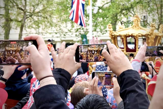 Capturing the historic moment on mobile phones of the passing of King Charles III & Queen Camilla in the Gold State Coach. Image Simon James Smith