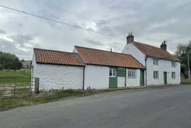 The whitewashed exterior of the cottage with annexe for sale in Folkton.