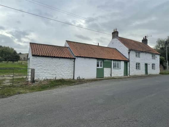 The whitewashed exterior of the cottage with annexe for sale in Folkton.