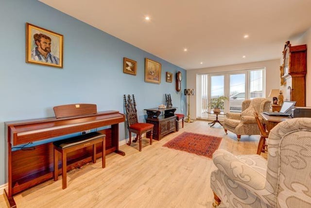 A versatile sitting or music room that could double as a further bedroom has doors that lead outside.
