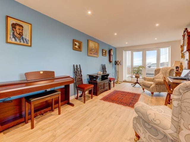 A versatile sitting or music room that could double as a further bedroom has doors that lead outside.