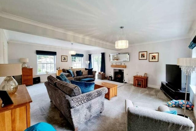 A very spacious lounge with feature fireplace and woodburner stove.