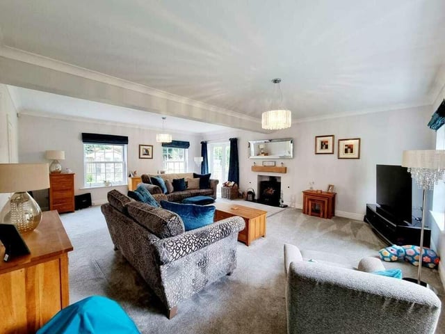 A very spacious lounge with feature fireplace and woodburner stove.