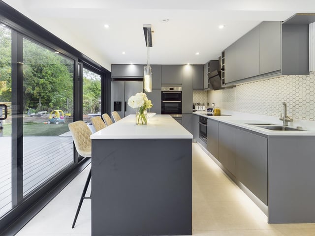 Sliding doors create a wall of windows and allow access from the kitchen to outside.