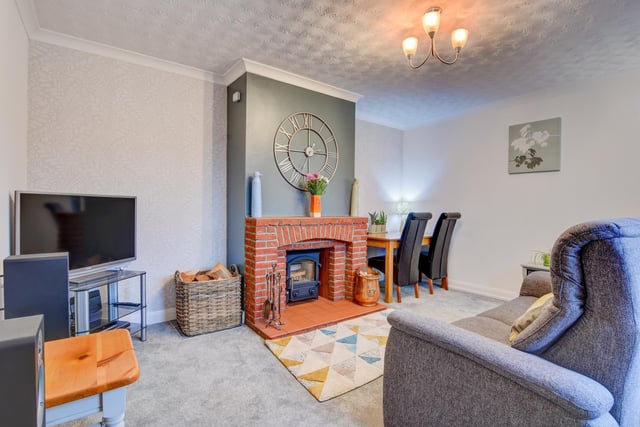 The sitting room with diner has a central feature brick fireplace with tiled hearth that contains a log burning stove.