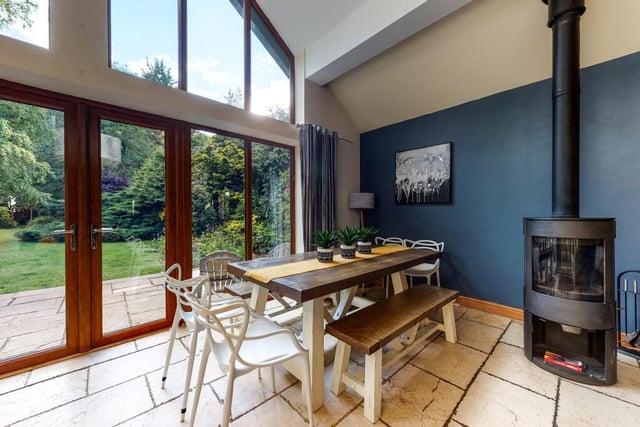 Dining space with a cosy multi-fuel burner and doors out to a patio.