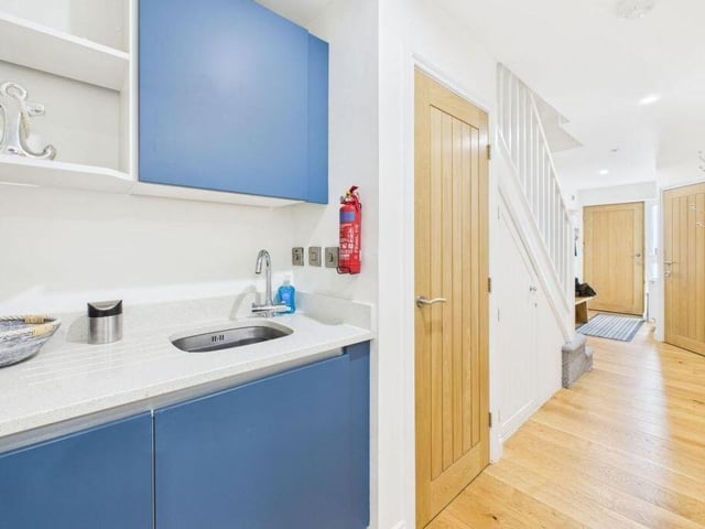 A light and airy hallway with staircase up leads through to the kitchen.