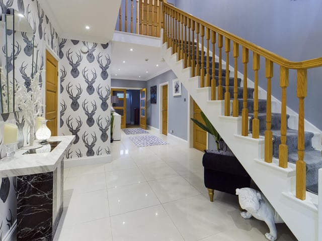 A staircase to the first floor gallery landing leads up from the impressive hallway.