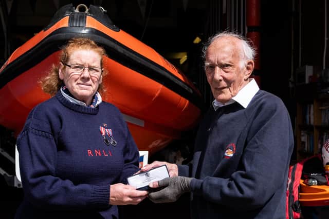 Liz Wilson being presented with her 20-year service medal by station chairman Neil Anderson during an RNLI 200th celebration at the station. picture: RNLI/James Stoker
