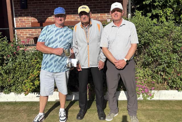 Paul Morgan, left, seals O60s Singles victory against home ace Barrie Watson, right, with Borough President Pete Hodgson, centre.