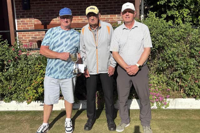 Paul Morgan, left, seals O60s Singles victory against home ace Barrie Watson, right, with Borough President Pete Hodgson, centre.