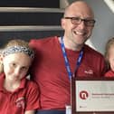 Headteacher Matthew Davis shows off the award with the help of pupils
