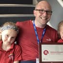 Headteacher Matthew Davis shows off the award with the help of pupils