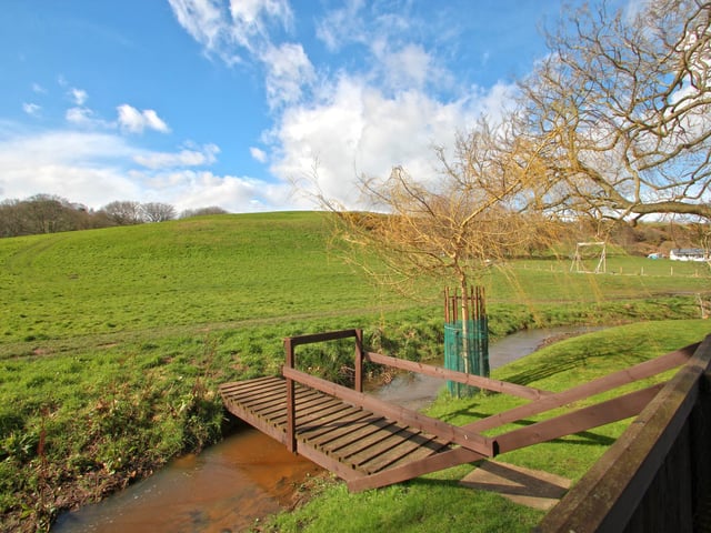 The stream with footbridge at the bottom of the garden.
