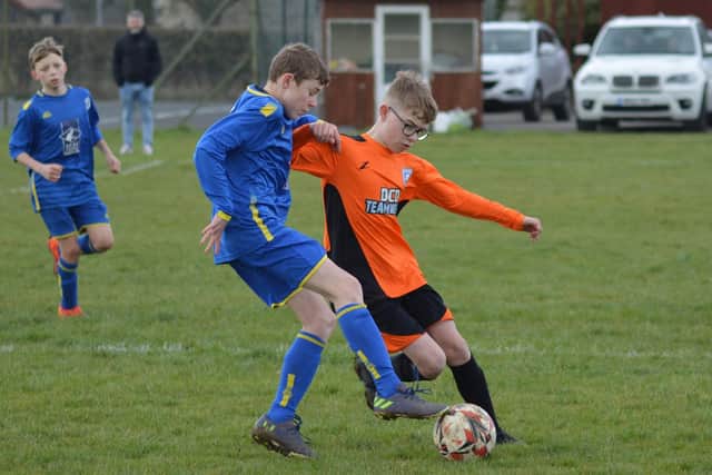 Heslerton Heroes Under-13s (orange kit) battle with Eastfield Under-13s