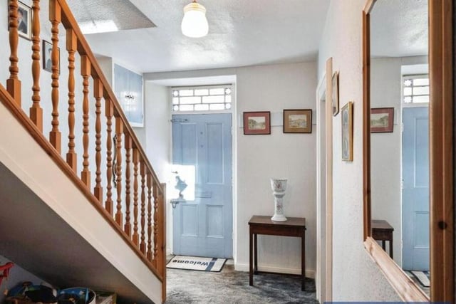 A spacious hallway with staircase leading up.