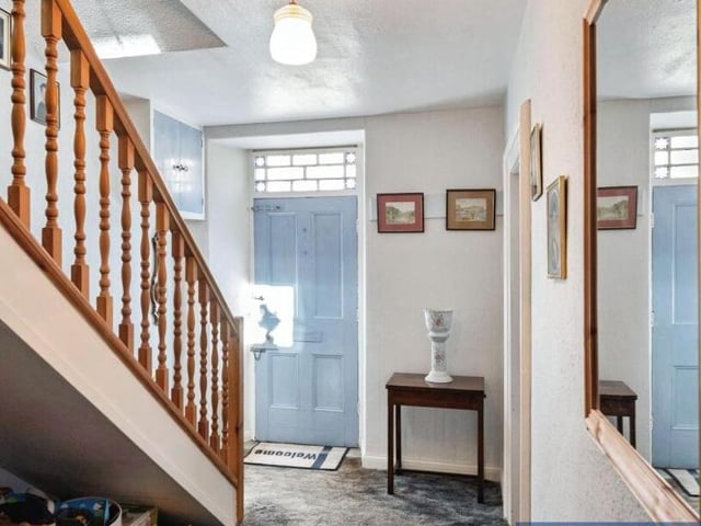 A spacious hallway with staircase leading up.