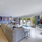 The ground floor living kitchen has glass doors to the decked seating areas outside, and the garden.