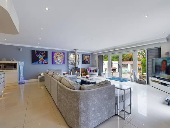 The ground floor living kitchen has glass doors to the decked seating areas outside, and the garden.
