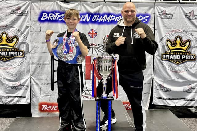 Typhon Martial Arts student Zach Tipping shows off his two silver medals at the national event, with Head Coach Pete Dicks looking on.