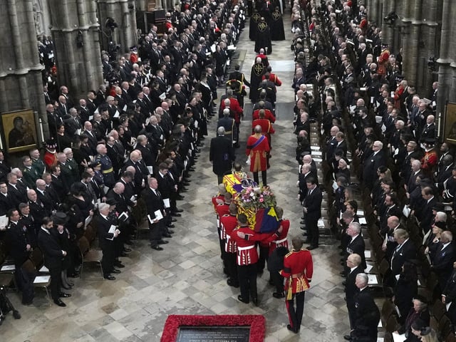 A Bearer Party of The Queen's Company, 1st Battalion Grenadier Guards carries the coffin of Queen Elizabeth II, draped in the Royal Standard, from the State Gun Carriage of the Royal Navy into Westminster Abbey. (Photo by Frank Augstein / POOL / AFP) (Photo by FRANK AUGSTEIN/POOL/AFP via Getty Images)