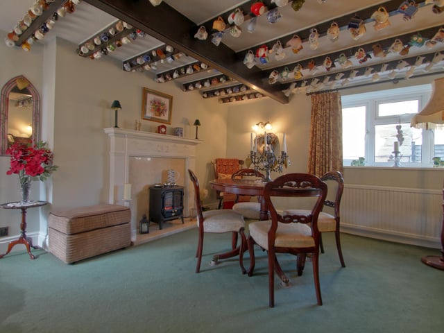 A beamed and versatile reception room with feature fireplace is used currently as a formal dining room.