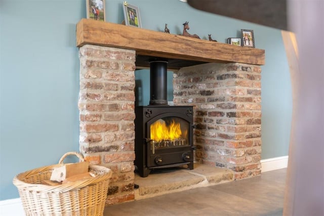 This rustic fireplace houses a multi-fuel burning stove that has a dual aspect, featuring in both dining room and kitchen.