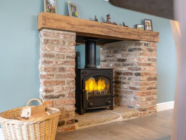 This rustic fireplace houses a multi-fuel burning stove that has a dual aspect, featuring in both dining room and kitchen.