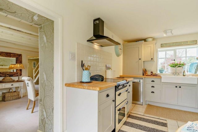 A country style breakfast kitchen with bespoke cabinets and oak worktops leads through to the dining room.